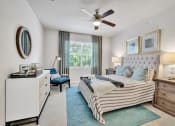 Thumbnail 6 of 25 - a bedroom with a bed and a ceiling fan