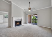 Thumbnail 18 of 25 - an empty living room with a fireplace and a ceiling fan
