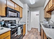 Thumbnail 27 of 32 - a kitchen with a sink and a stove and a microwave