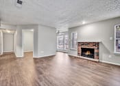 Thumbnail 19 of 32 - an empty living room with a fireplace and hardwood floors
