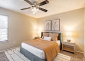 Thumbnail 8 of 31 - Bedroom with upholstered headboard and nightstand at Highland Park Apartments, Fort Worth, 76132