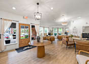 Thumbnail 1 of 32 - A well-lit waiting room with a wooden floor and a variety of seating options.