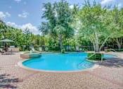 Thumbnail 7 of 25 - a swimming pool with trees and a fence around it