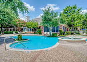Thumbnail 14 of 25 - a swimming pool with a fountain in front of an apartment building