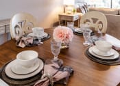 Thumbnail 12 of 106 - a dining room table set with plates and glasses