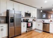 Thumbnail 5 of 106 - a kitchen with white cabinets and stainless steel appliances