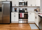 Thumbnail 6 of 106 - a kitchen with white cabinets and stainless steel appliances