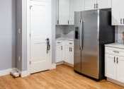 Thumbnail 7 of 106 - a kitchen with white cabinets and a stainless steel refrigerator