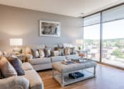Thumbnail 14 of 106 - a living room with a large window and a view of the city