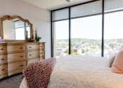 Thumbnail 20 of 106 - a bedroom with a large window and a dresser with a mirror
