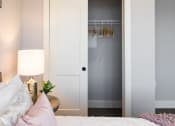 Thumbnail 23 of 106 - a bedroom with a bed and a closet with a door open