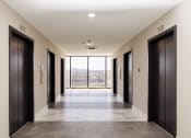 Thumbnail 35 of 106 - a long corridor with black doors and a view of the mountains