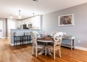 Thumbnail 11 of 106 - a dining area with a table and chairs and a kitchen in the background