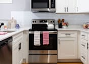 Thumbnail 87 of 106 - A modern kitchen with a stove top oven and microwave above it.