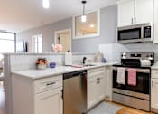 Thumbnail 86 of 106 - A modern kitchen with a stainless steel dishwasher and oven.