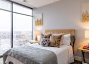 Thumbnail 88 of 106 - A bedroom with a large window overlooking a cityscape.