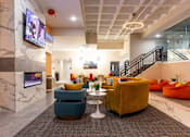 Thumbnail 43 of 106 - a lobby with couches and chairs and a television