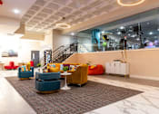 Thumbnail 42 of 106 - a lobby with couches and chairs and a staircase