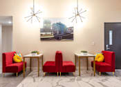 Thumbnail 46 of 106 - a living room with red chairs and a painting on the wall