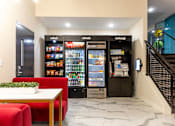 Thumbnail 48 of 106 - a lobby area with red couches and refrigerators    and a staircase