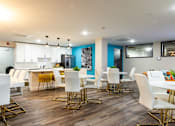 Thumbnail 76 of 106 - a dining room with white chairs and tables and a kitchen