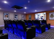 Thumbnail 73 of 106 - a theater room with blue chairs and a projector screen
