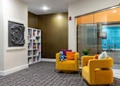 Thumbnail 56 of 106 - a living room with yellow chairs and a television