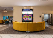 Thumbnail 40 of 106 - the lobby of a hotel with a large yellow couch in the center of the room