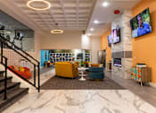 Thumbnail 44 of 106 - a lobby with couches and chairs and a tv on the wall
