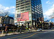 Thumbnail 4 of 106 - a large flag in front of a tall building