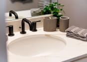 Thumbnail 11 of 33 - A white sink with a black faucet and towels.