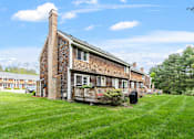 Thumbnail 34 of 53 - A brick house with a chimney and a porch.