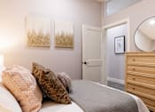 Thumbnail 36 of 38 - A bedroom with a bed, two pillows, a dresser, and a mirror.