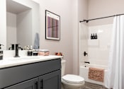 Thumbnail 27 of 38 - A bathroom with a toilet, sink, and shower.