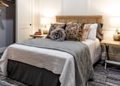 Thumbnail 35 of 38 - A bedroom with a bed, pillows, and a nightstand.