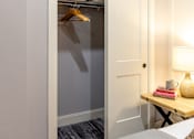 Thumbnail 37 of 38 - A white door is open to a small closet with a hanger and a pillow.