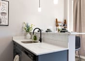 Thumbnail 6 of 38 - A kitchen with a sink and a framed poster on the wall.