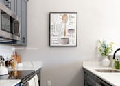 Thumbnail 7 of 38 - A kitchen with a framed picture on the wall.