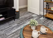 Thumbnail 11 of 38 - A living room with a grey carpet and a wooden coffee table.