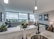 Thumbnail 20 of 33 - an open kitchen and living room with a large window and a sink