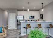 Thumbnail 18 of 33 - a kitchen and living room with white cabinets and a counter