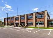 Thumbnail 68 of 84 - A large building with a parking lot in front of it.