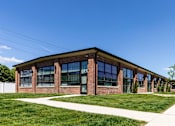 Thumbnail 69 of 84 - A modern building with a brick facade and large windows.