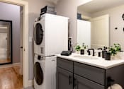 Thumbnail 15 of 84 - A white washing machine and dryer stacked on top of each other in a laundry room.