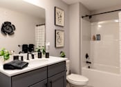 Thumbnail 16 of 84 - A bathroom with a white sink and a white toilet.