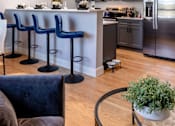Thumbnail 1 of 84 - A kitchen with a bar area and blue chairs.