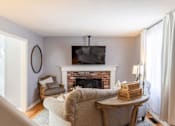 Thumbnail 5 of 53 - A living room with a fireplace and a chair.