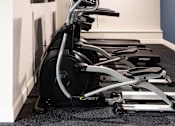 Thumbnail 31 of 50 - A row of stationary bikes are lined up in a room.