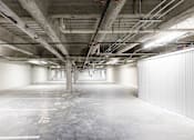 Thumbnail 35 of 50 - A large, empty parking garage with concrete floors and walls.