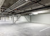 Thumbnail 34 of 50 - A large, empty parking garage with concrete floors and walls.